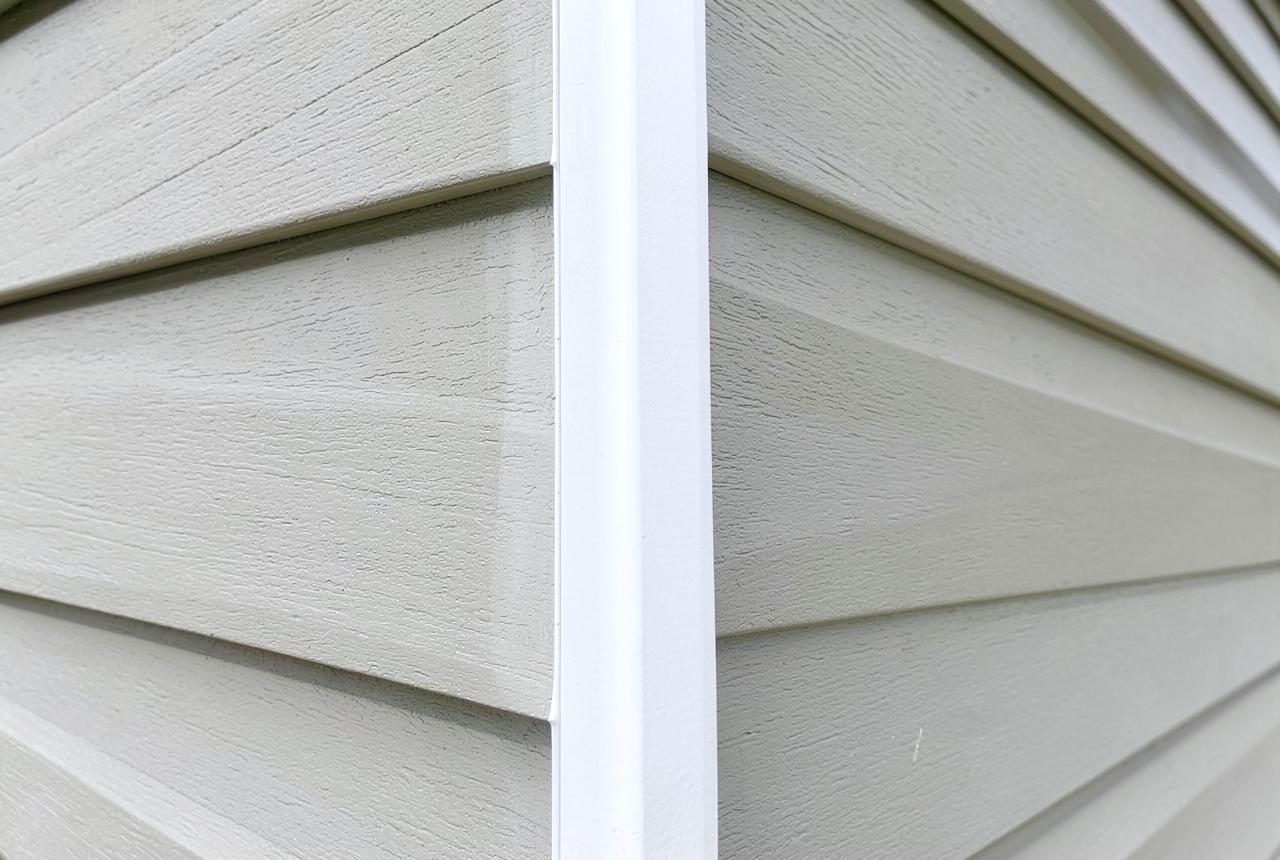 Close-up of newly installed fiber cement lap siding with white corner trim on a Sacramento home